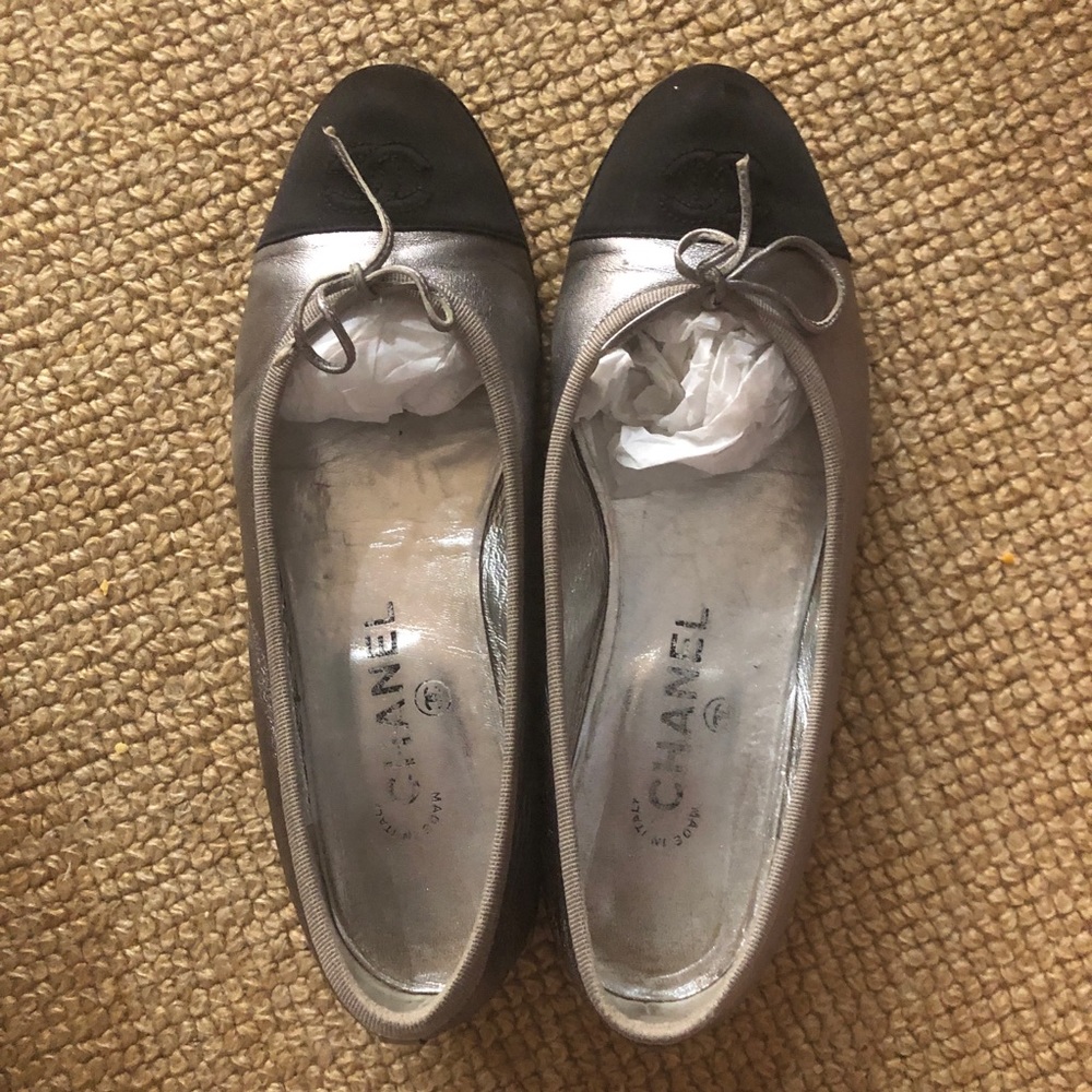 Channel silvery gray with black toe tip ballet slipper type flats.
